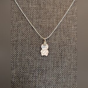 White Mummy Pendant With Small Charm On A White Necklace